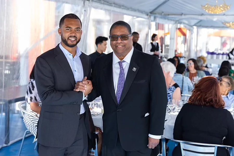 Chandler greeting a guest at a waterfront gala
