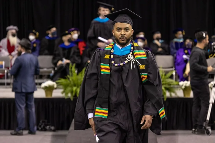 Chandler crossing the stage at his University of Washington graduation, 2022
