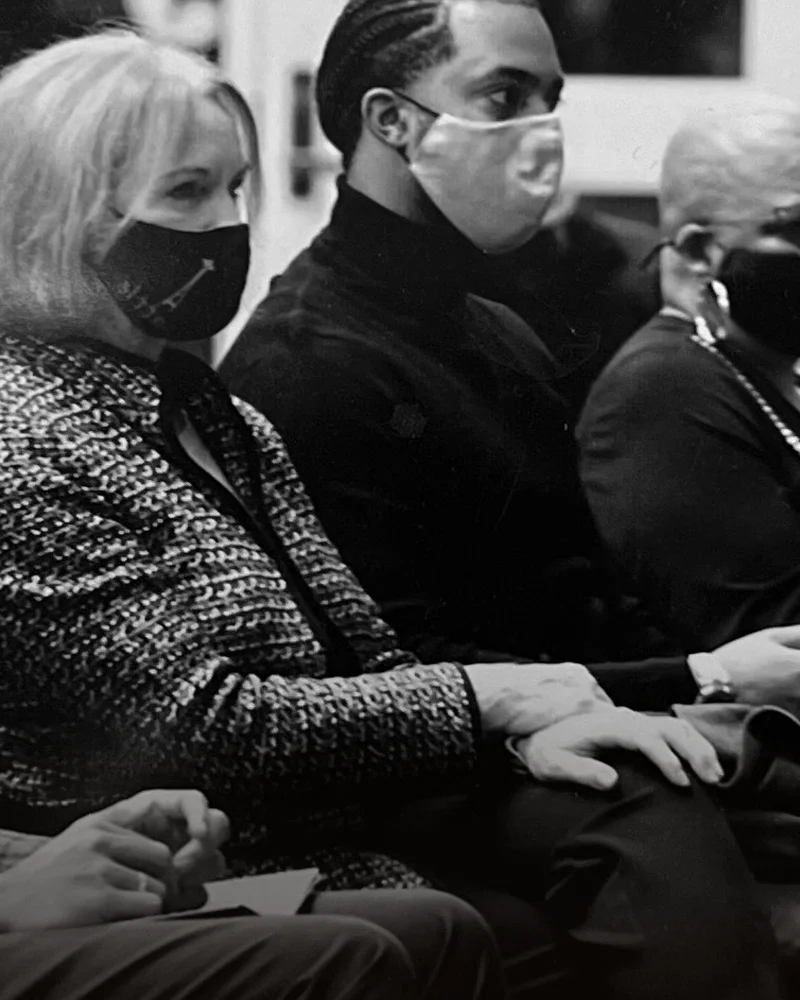 Chandler Walker Gayton seated among community members at a gathering